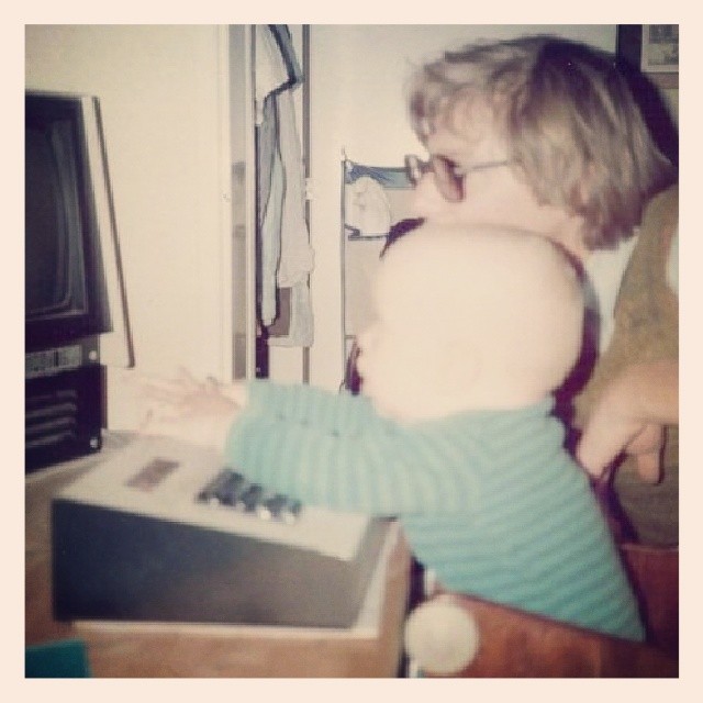 Image of me and my father in front of a terminal in 1986, 3 years old. I'm at the keyboard. We're both staring at the screen.